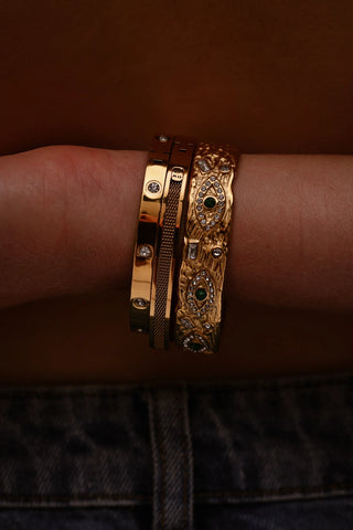 Layered bracelet look featuring chunky and delicate gold designs