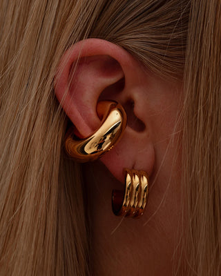 Elegant woman styling layered earrings from Queen & Co. collection