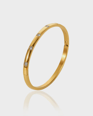 "Close-up of the Istanbul Bracelet by Queen & Collection, featuring a sleek gold-plated cuff adorned with five sparkling cubic zirconia stones, offering a minimalist yet elegant design."

