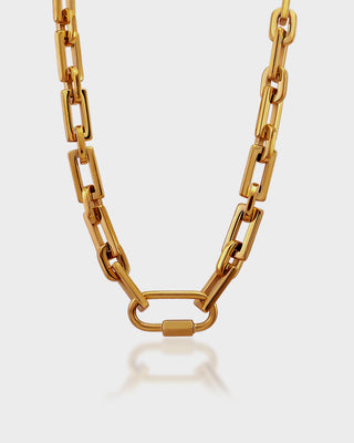 Gold chain necklace on a light gray background