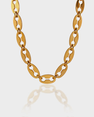 Gold chain necklace on a light gray background