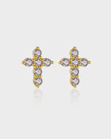 Gold cross earrings with clear gemstones on a light gray background