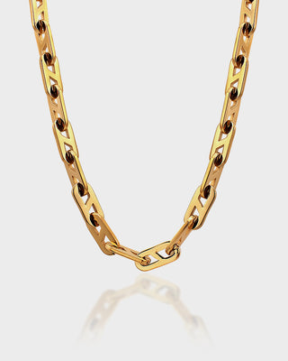 Gold chain necklace on a light gray background