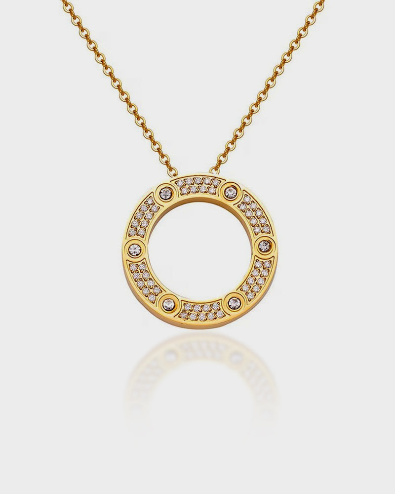 Gold necklace with a circular pendant on a light gray background