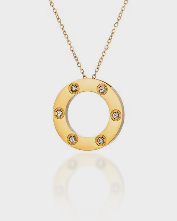 Gold necklace with a circular pendant featuring small diamonds on a white background