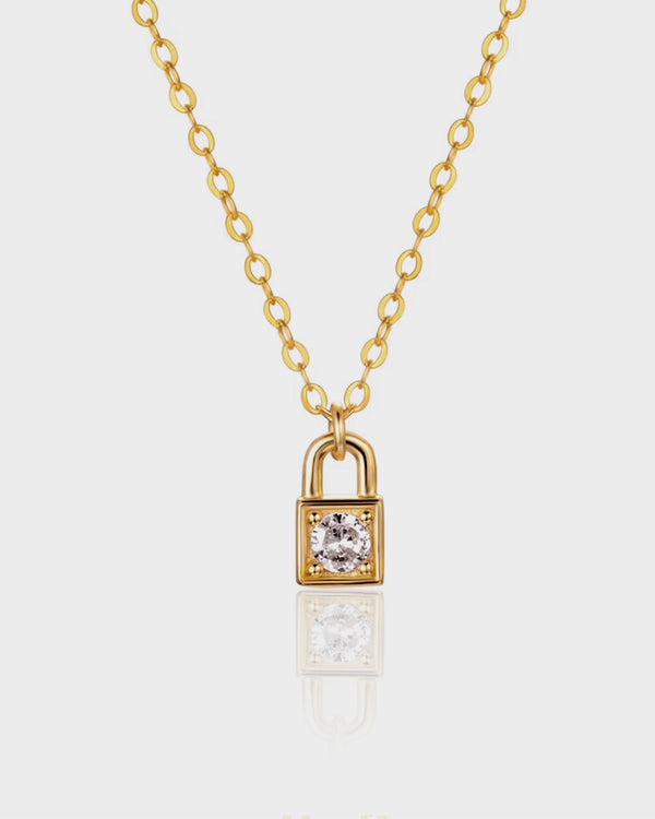 Gold padlock-shaped necklace with a diamond on a white background
