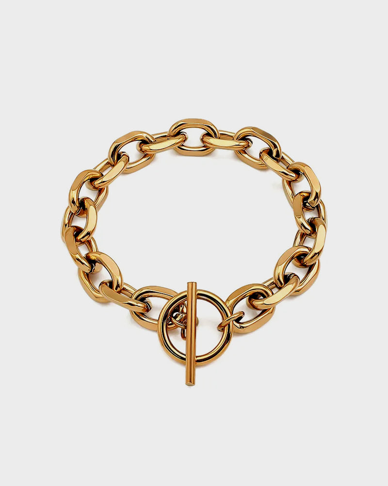 Add a touch of timeless elegance with the Pera Bracelet from Queen and Co. Featuring a sleek gold-plated design, this piece is perfect for layering or wearing solo. Shop now for luxurious, high-quality jewelry.