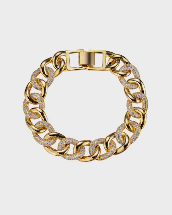 Gold chain bracelet with diamond accents on a light gray background