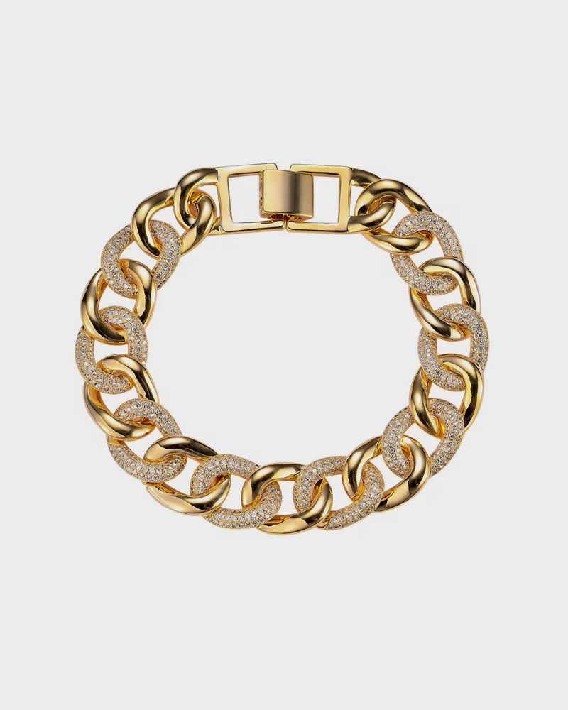 Gold chain bracelet with diamond accents on a light gray background