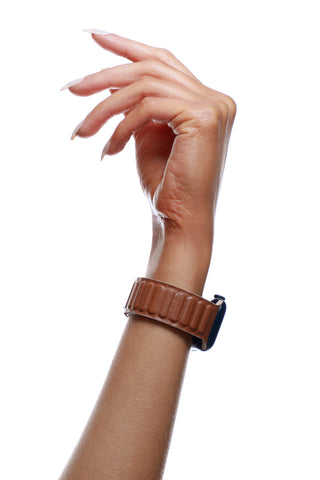 Hand wearing a brown watch on a white background
