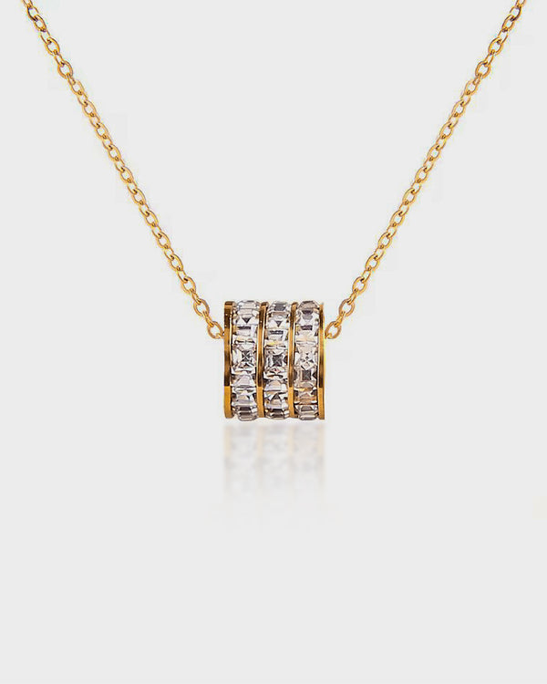 Gold necklace with a diamond pendant on a white background