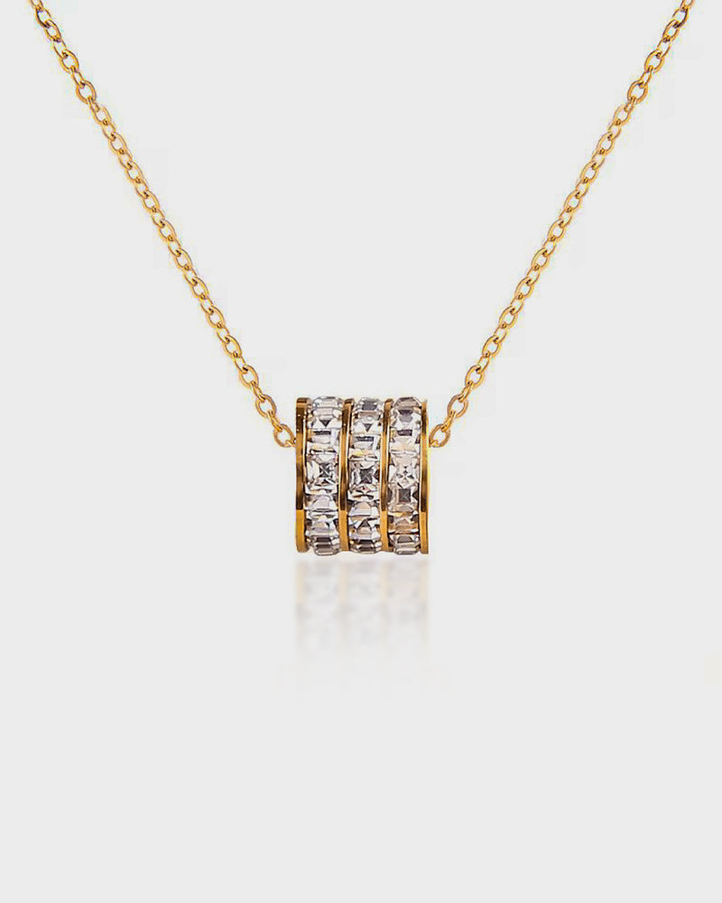 Gold necklace with a diamond pendant on a white background