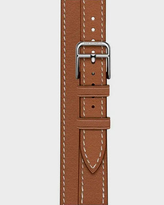 Brown leather watch strap with silver buckle on a light gray background