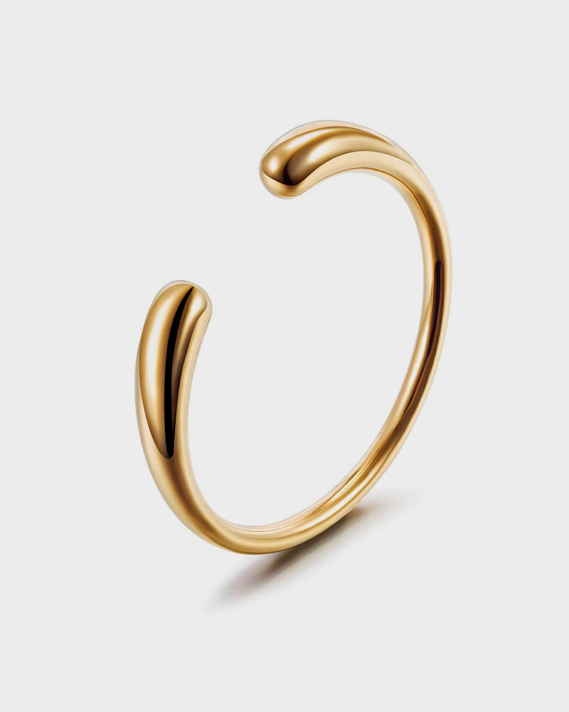 Gold bracelet on a light gray background