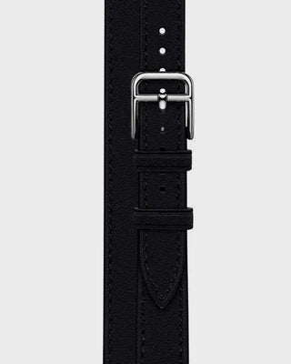 Black watch strap with silver buckle on a light gray background