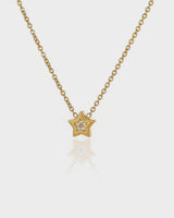 Gold star-shaped necklace with a diamond on a white background