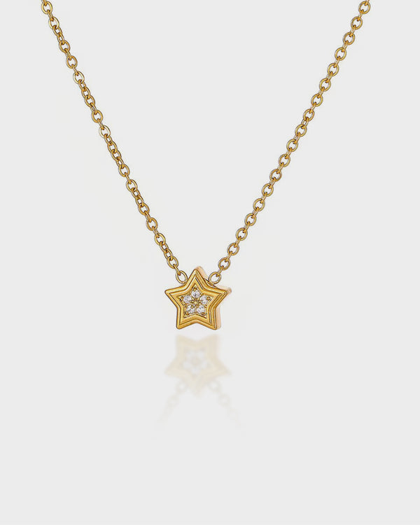 Gold star-shaped necklace with a diamond on a white background