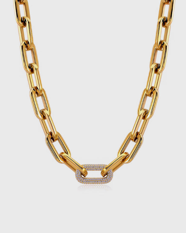 Gold chain necklace with a diamond clasp on a light gray background
