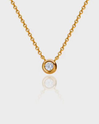 Gold necklace with a diamond pendant on a white background