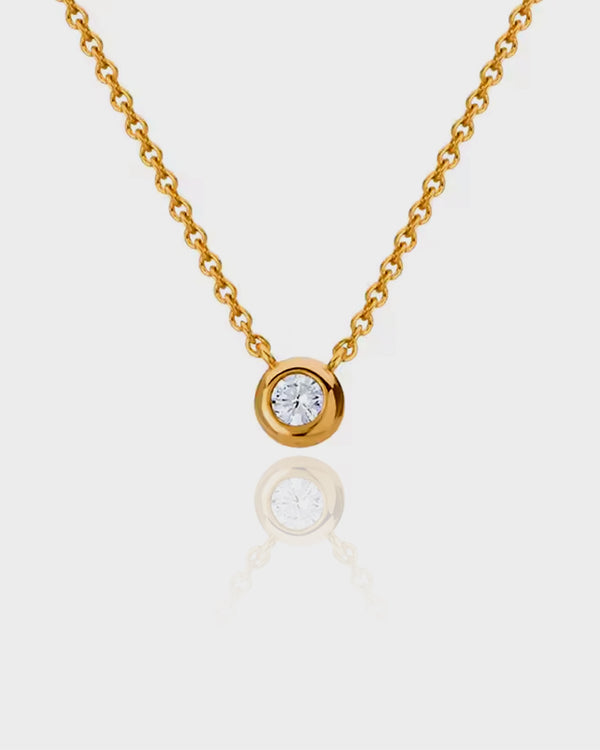 Gold necklace with a diamond pendant on a white background