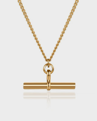 Gold necklace with a cylindrical pendant on a light gray background