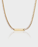 Gold necklace with a bar pendant on a light gray background
