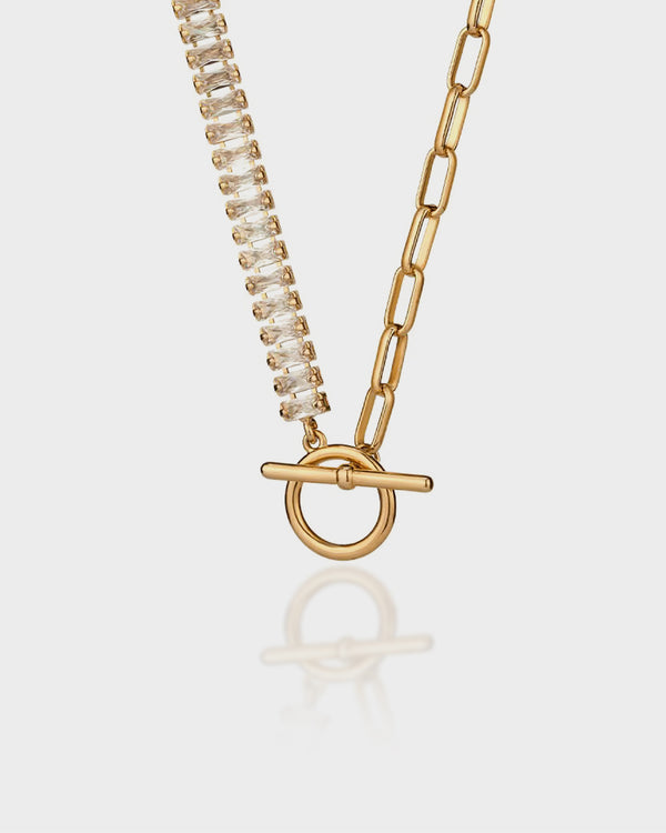 Gold necklace with a toggle clasp on a light gray background