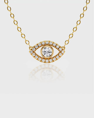 Gold necklace with an eye-shaped pendant on a light gray background
