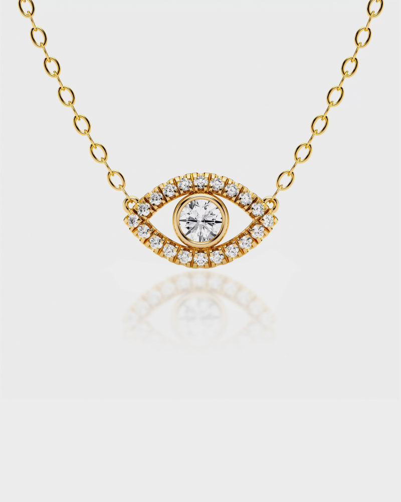 Gold necklace with an eye-shaped pendant on a light gray background