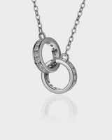 Silver necklace with interlocking rings on a light gray background