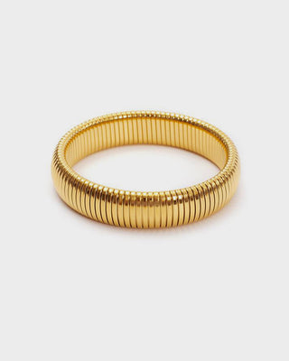 Gold bracelet on a light gray background