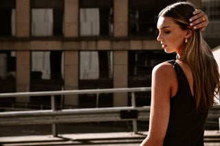 "Pera Earrings displayed against a neutral backdrop, highlighting their sleek, sculpted design and radiant gold finish."

