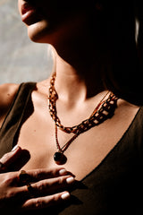 "Model wearing the Statement Necklace layered with other gold chains, showcasing its versatility and elegant design."

