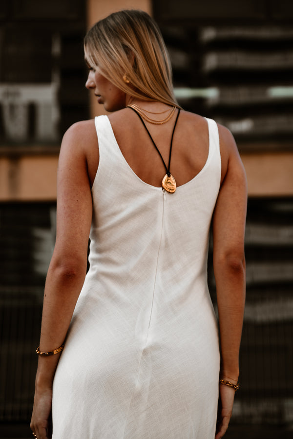 "Model wearing the Nirvana Necklace layered with complementary gold chains, emphasizing its elegant design and versatility."

