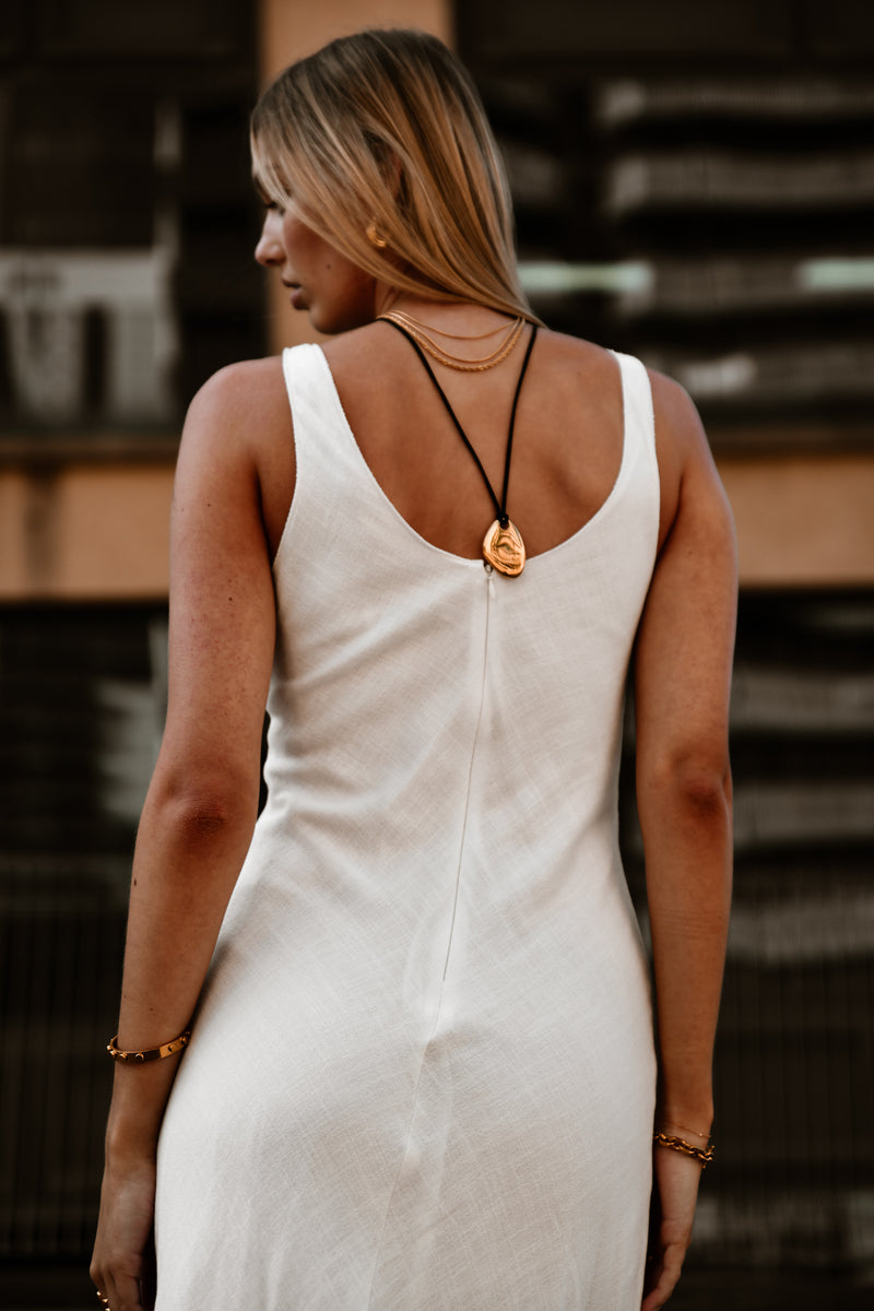 "Model wearing the Nirvana Necklace layered with complementary gold chains, emphasizing its elegant design and versatility."

