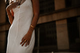 "Manifest Bracelet displayed against a neutral backdrop, highlighting its polished gold-plated finish and versatile design."

