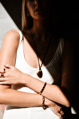 "Nirvana Necklace displayed against a neutral backdrop, accentuating its intricate gold detailing and timeless appeal."
